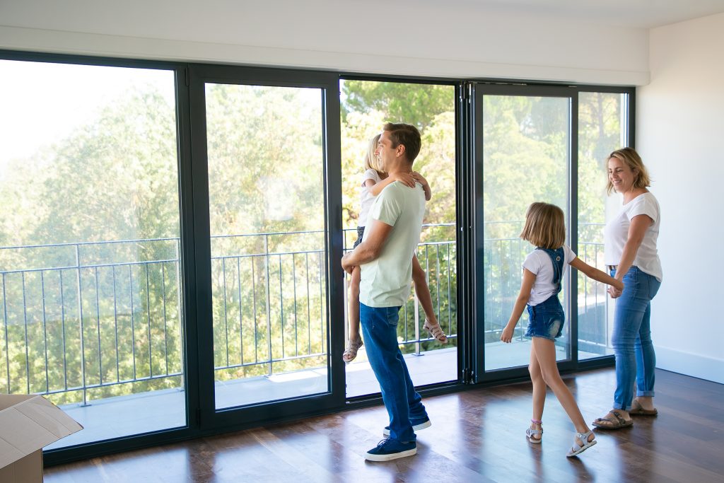 happy father with daughter standing near open balcony smiling 1